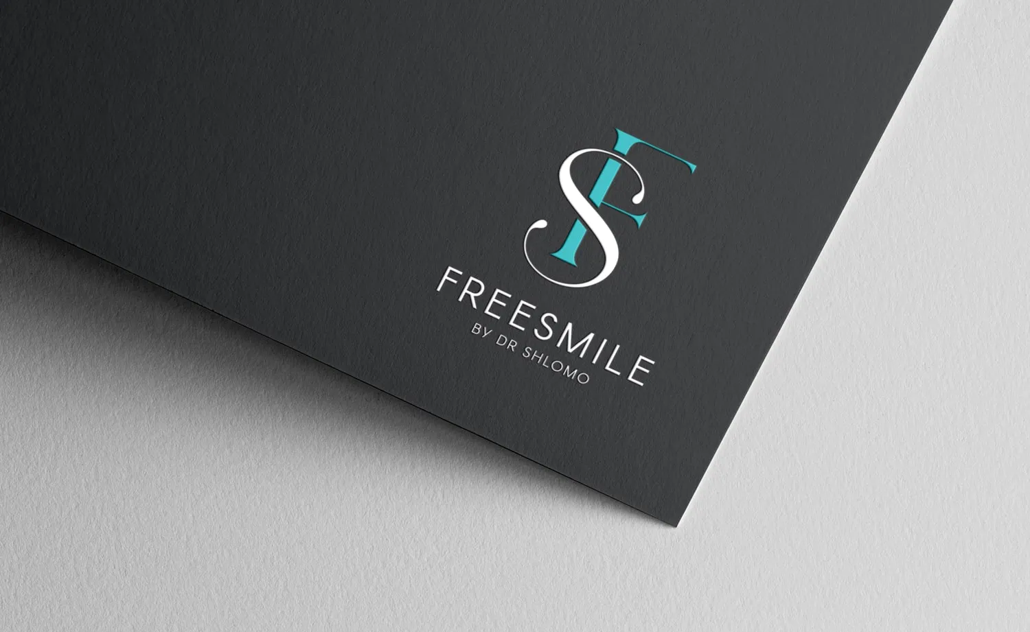 המיתוג של FreeSmile: הלוגו על נייר אפור כהה
